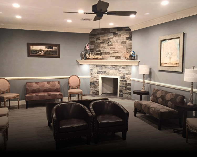 Modern dental office waiting room with fireplace, comfortable seating, and contemporary decor.