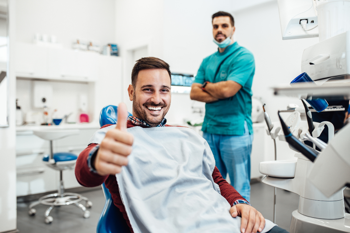 Happy dental patient giving thumbs up after treatment at Williamson dental practice.
